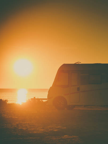 istock Camper car on beach at sunset 1284907631