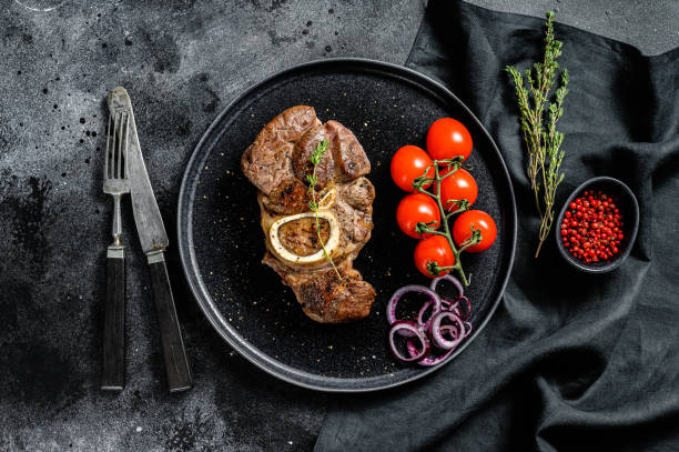 istock Osso buco, cooked Veal shank. Ossobuco meat. Black background. Top view 1284907790