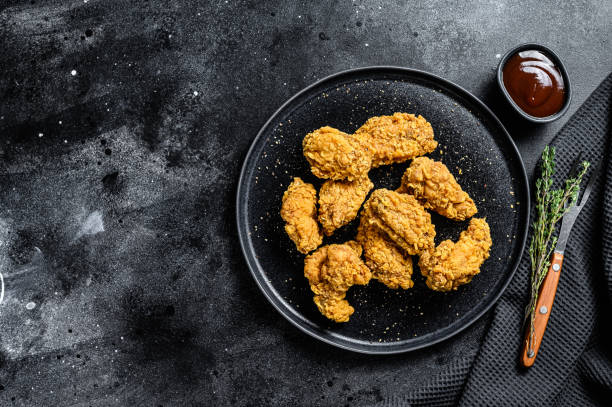 istock homemade baked crispy chicken wings.  Black background. Top view. Copy space 1284908182