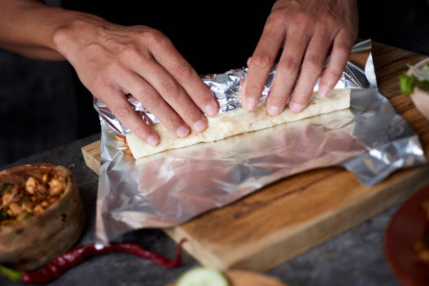 istock man wrapping a durum or a burrito 1284908188