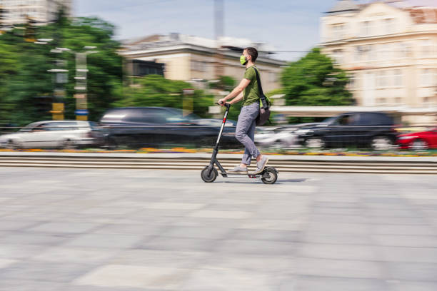 istock Young man riding e-scooter in the city 1284908395