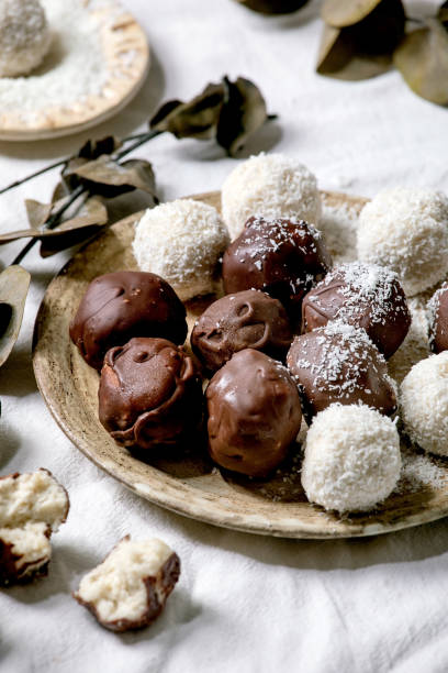 istock Raw vegan coconut chocolate candy balls over white with eucalyptus branches 1284909721