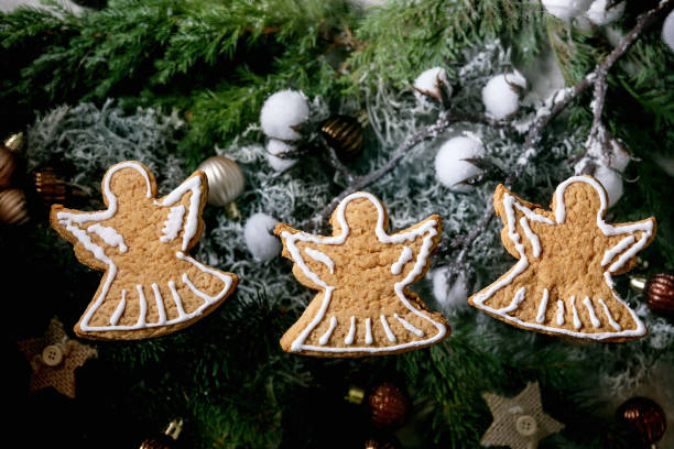 istock Christmas gingerbread angels cookies with icing ornate. Xmas decorations, dark background. Top view 1284909764