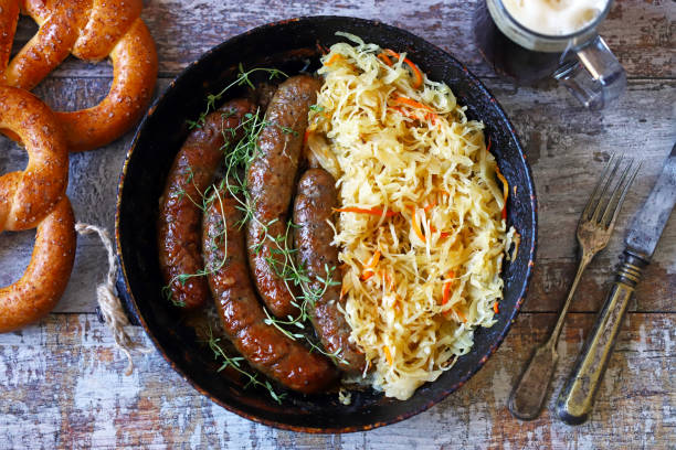 Bavarian sausages in a pan with stewed sauerkraut. stock photo
