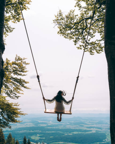 istock Woman sitting on swing in mountains 1284912568