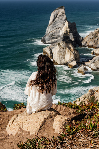 Woman looking at view on beach on windy day