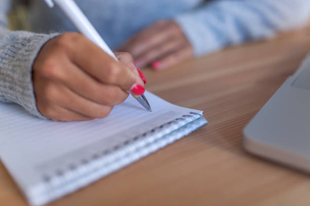 istock Close up of unrecognizable woman taking notes. 1284913901