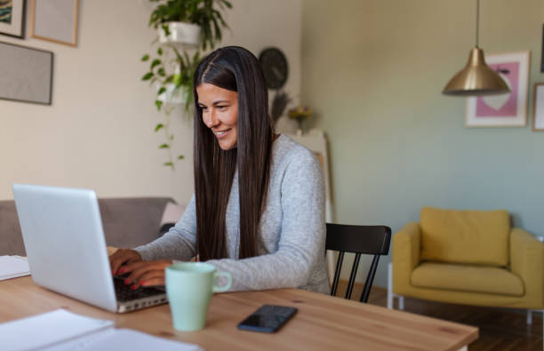 istock Happy woman typing an e-mail on laptop at home. 1284913921