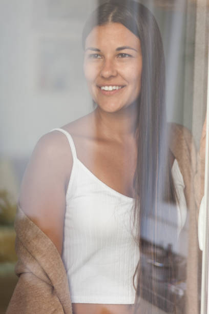 istock Happy woman looking through window during home quarantine. 1284913929