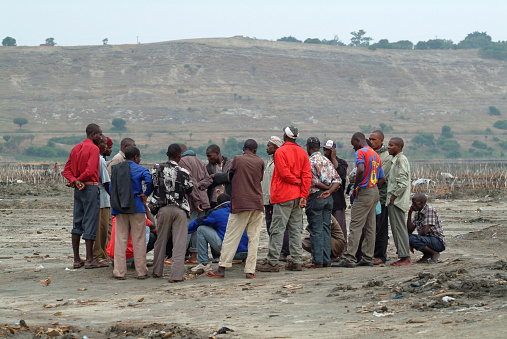 Katwe, Uganda - Aug 30, 2010: Group of the local men awaiting an order to work. Katwe salt lake is a customary lake on which salt mining is done, formed many years long ago by volcanic eruption