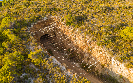 View of a hole in the ground with a dirt road and an entrance to a tunnel