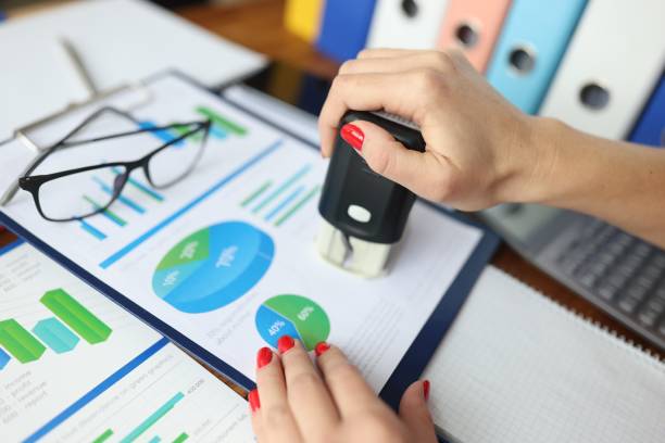 istock Woman puts stamp on documents with commercial indicators. 1284915983