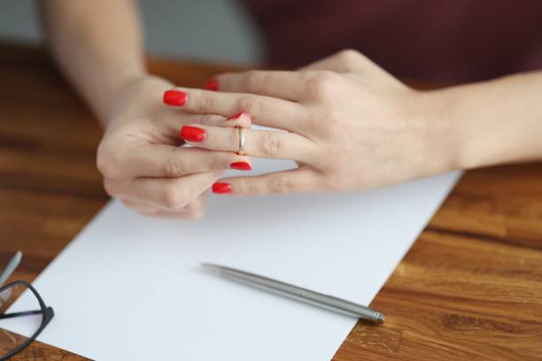 Woman's hand removes wedding ring from her finger.