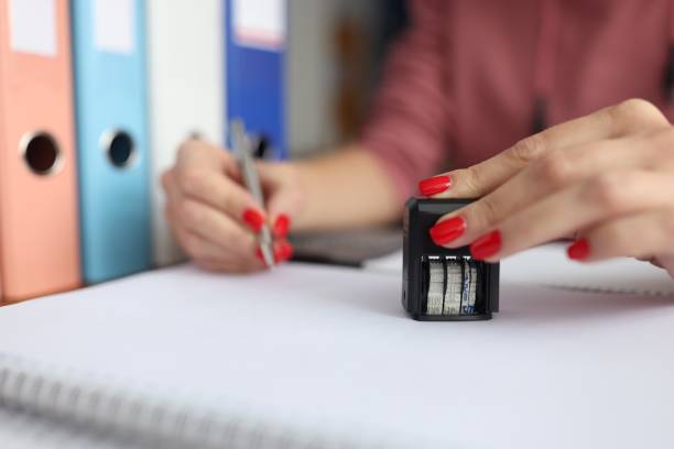 istock Female hand holds pen and seal for documents. 1284915989