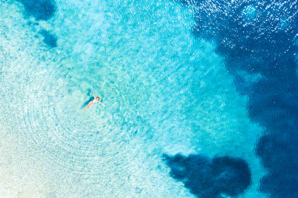 istock Woman in bikini floating on water on back 1284916199