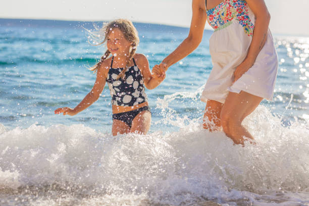 Mother and daughter on summer vacations playing in the sea together