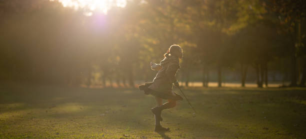 istock Girl playing in the park at sunset 1284917643