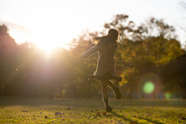 Girl playing in the park at sunset