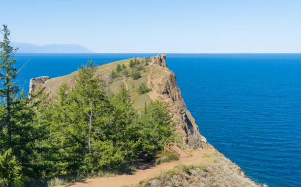 capo khoboy, costa rocciosa. punta settentrionale dell'isola di olkhon sul lago baikal. concetto di viaggio. il lago baikal è il più grande lago d'acqua dolce del mondo. bellissimo paesaggio del lago baikal siberiano. - larch tree stone landscape sky foto e immagini stock