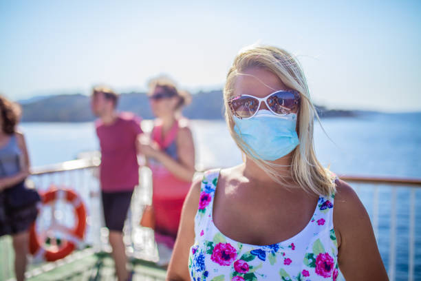 femme sur le bateau de croisière avec le masque protecteur de visage - clothing satisfaction enjoyment day photos et images de collection