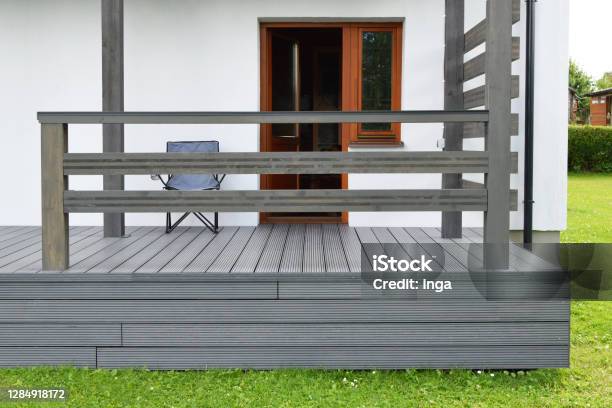 Part Of White Residential House With Dark Gray Composite Material Terrace Deck With Wooden Railings Stock Photo - Download Image Now