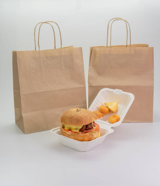 istock hamburger in a takeaway container and a paper bag on a white background 1284919171