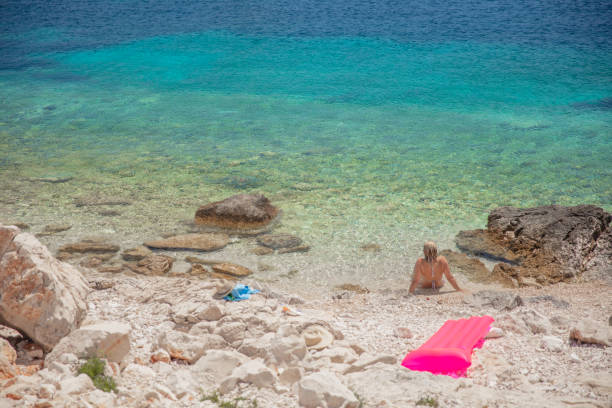 istock Woman relaxing on a sandy beach 1284919423