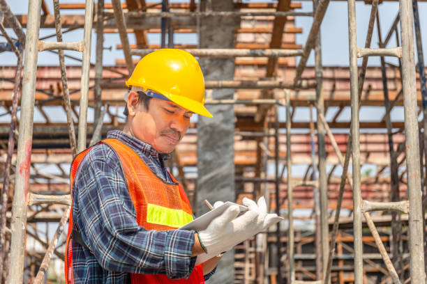 istock Worker man in hard hat holding clipboard checklist at construction site 1284919492