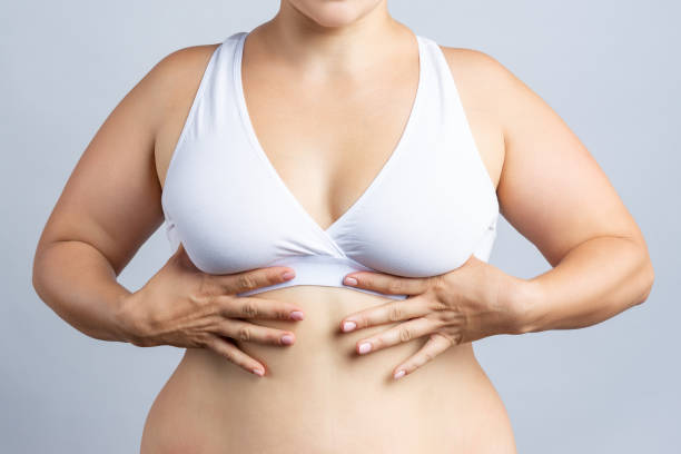 istock Big natural breasts in white bra close-up on gray background 1284920162