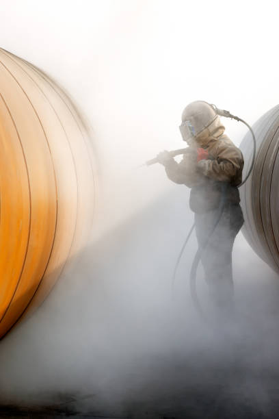 istock Manual sandblasting or abrasive blasting to metal pipe. Abrasive blasting, more commonly known as sandblasting, is the operation of forcibly propelling a stream of abrasive material against a surface. 1284920649