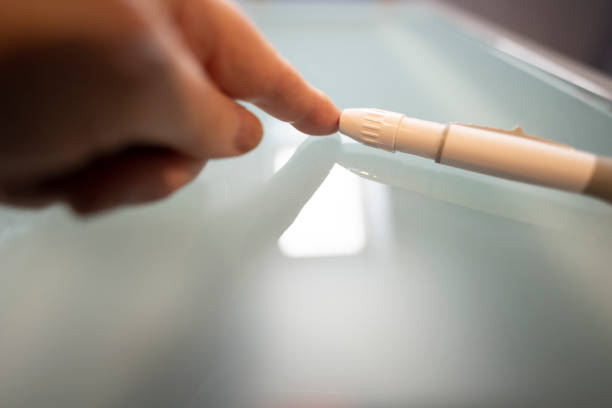 istock using needle pen to draw blood to test blood sugar - diabetes diabetic 1284922426