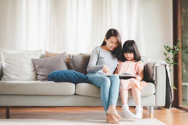 istock Asian mother and daughter reading a book 1284922433