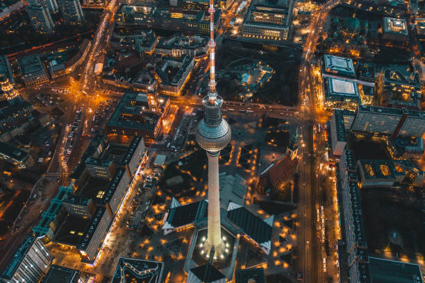 berlín, alemania alexanderplatz torre de tv después de sunset at dusk con hermosas calles iluminadas en luces naranjas de un paisaje urbano de la gran ciudad, vista aérea - berlin germany fotografías e imágenes de stock