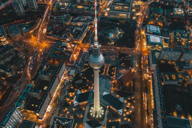 Berlin, Germany Alexanderplatz TV Tower after Sunset at Dusk with beautiful lit up Streets in orange lights of a Big City Cityscape, Aerial View HQ