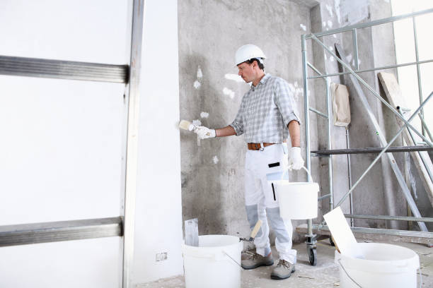 istock plasterer man work holds a bucket and use the brush wet the wall before application to interior construction site wear helmet and protective gloves, ladder and scaffolding on background 1284925486