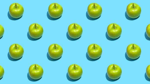 istock Fruit pattern of fresh green apples on blue background. Top view. Summer concept. Collage 1284925683