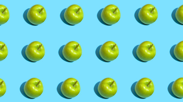 istock Fruit pattern of fresh green apples on blue background. Top view. Summer concept. Collage 1284925699