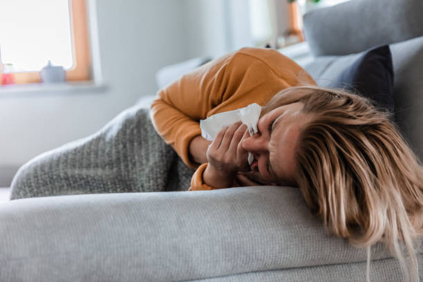 Sick woman lying on the sofa and coughing