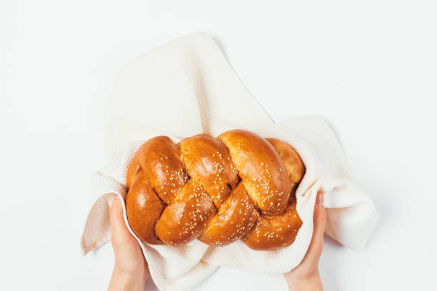 Female hands hold loaf of fresh wheat bread
