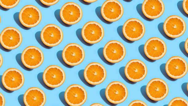 istock Fruit pattern of fresh orange slices on blue background. Top view. Summer concept. Collage 1284926504