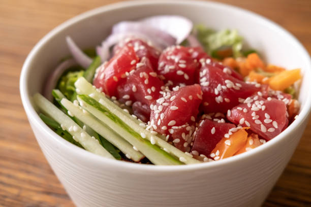 오이, 쌀, 당근, 양파를 곁들인 건강한 유기농 생 참치 찌르기 그릇이 나무 테이블에 그릇에 담겨 있습니다. 건강한 라이프스타일 - tuna food seafood japanese culture 뉴스 사진 이미지