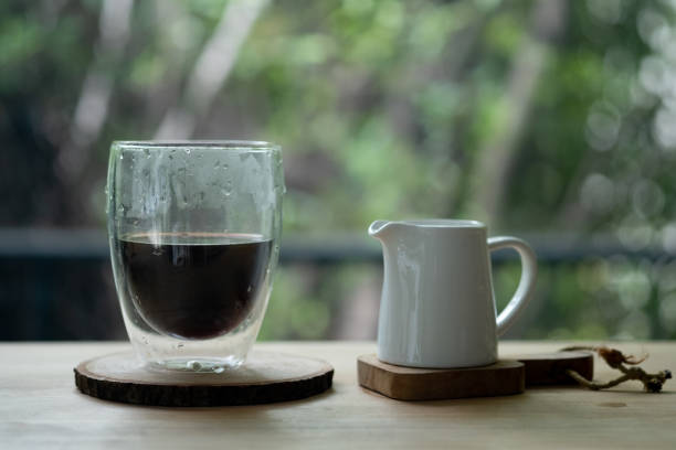 istock Morning black coffee in glass with fresh milk in ceramic jar on table 1284927650