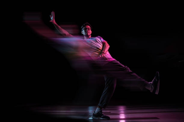 bailarín de break profesional saltando, practicando la danza hip-hop moderna en luz de neón rosa, efecto borroso - handsome man flash fotografías e imágenes de stock