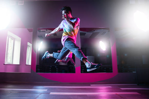 プロのブレイクダンサー、ピンクのネオンライトで現代ヒップホップダンスを練習 - handsome man flash ストックフォトと画像