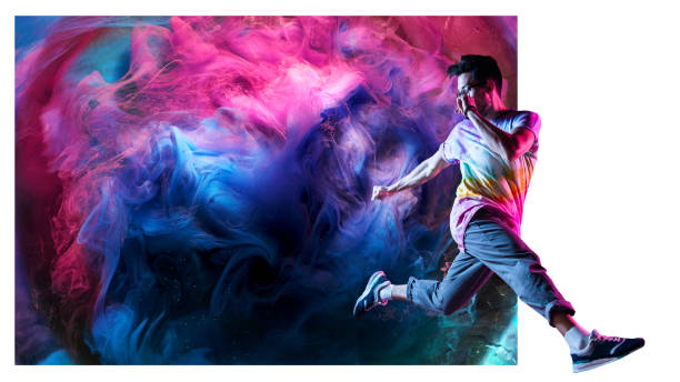 Professional break dancer posing in motion, practicing modern hip-hop dance against the background of abstract colorful smoke
