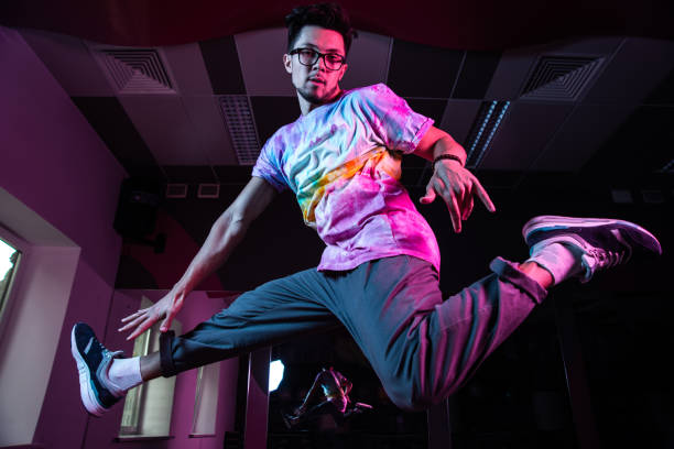 istock Professional break dancer in motion, practicing modern hip-hop dance in pink neon light 1284929322