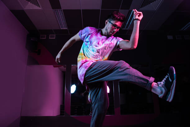 istock Professional break dancer in motion, practicing modern hip-hop dance in pink neon light 1284929327
