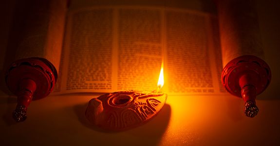 Una lámpara antigua que ilumina el texto hebreo de la Torá photo