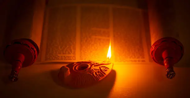 Photo of An Ancient Lamp Illuminating the Hebrew Text of the Torah