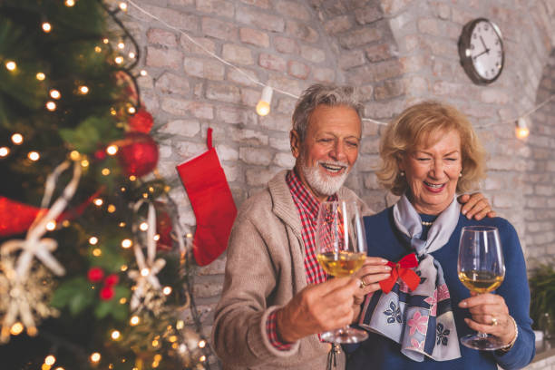 istock Senior couple drinking wine by the Christmas tree 1284937186
